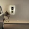 level 2 ev charger mounted in a home garage with electric car